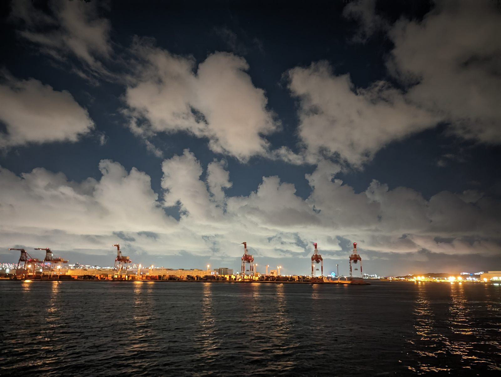 Container terminal at night, ship-to-shore cranes along the quay